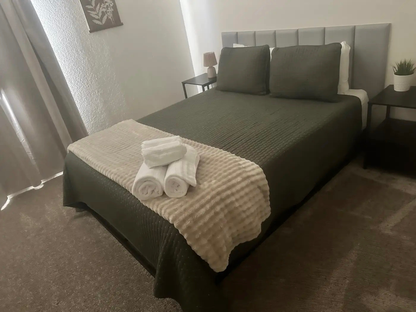 Guest-ready bed with fresh towels staged for a vacation rental